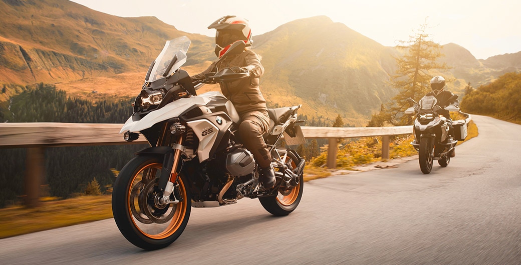 Primo piano di una R 1250 GS in sosta alla luce del sole con il motociclista sullo sfondo